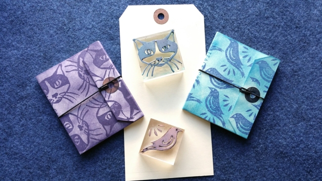 Block prints of a cat and a bird made into small books.